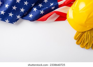 Saluting construction workers on Labor Day: A compelling overhead composition displaying the American flag and protective gear on white backdrop. Perfect for Labor Day campaigns or text overlays - Shutterstock ID 2338660725