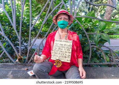 Salvador, Bahia, Brazil - April 09, 2022: A Woman Protesting Against Far-right Presidential Candidate Jair Bolsonaro, With Posters Reporting Bad Management.