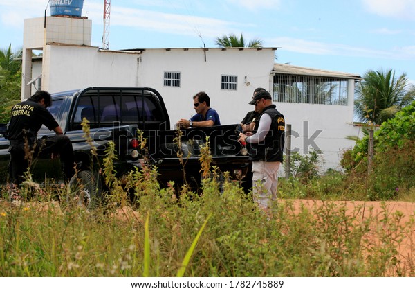 salvador,\
bahia / brazil - april 15, 2014: agents of the Federal Police of\
Brazil are seen during an action in operation aimed at repressing\
clandestine extraction of sand in\
Camacari.