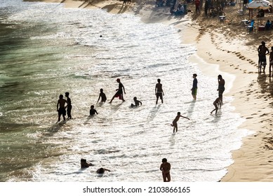 Salvador, Bahia, Brazil - August 22, 2021: Large Group Of People On Paciencia Beach In The Rio Vermelho Neighborhood Of Salvador, Brazil. People Having Fun In The Middle Of The Coronavirus Pandemic.