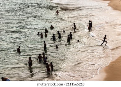 Salvador, Bahia, Brazil - August 22, 2021: Large Group Of People On Paciencia Beach In The Rio Vermelho Neighborhood Of Salvador, Brazil. People Having Fun In The Middle Of The Coronavirus Pandemic.