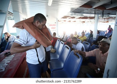 Salvador, Bahia, Brazil - August 28, 2017: A Crew Member Of A Speedboat Demonstrates The Life Jacket While Crossing The Waters Of The Baía De Todos Os Santos.