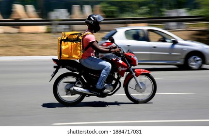 Salvador, Bahia, Brazil - December 30, 2020: Delivery Of Food By Application Is Seen Using A Motorcycle In The Pituba Neighborhood, In The City Of Salvador.