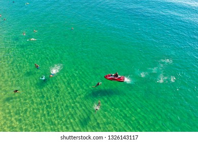 SALVADOR, BAHIA, BRAZIL - FEB 26, 2019: Porto Da Barra Beach, People Swimming On A Beautiful Emerald Green Water. 