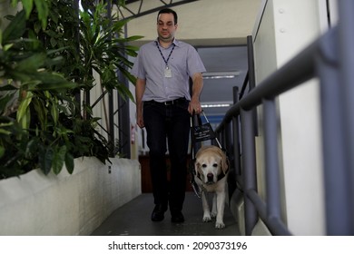 Salvador, Bahia, Brazil - March 20, 2019: Visually Impaired Uses A Guide Dog To Get Around In Their Work Activities In The City Of Salvador.