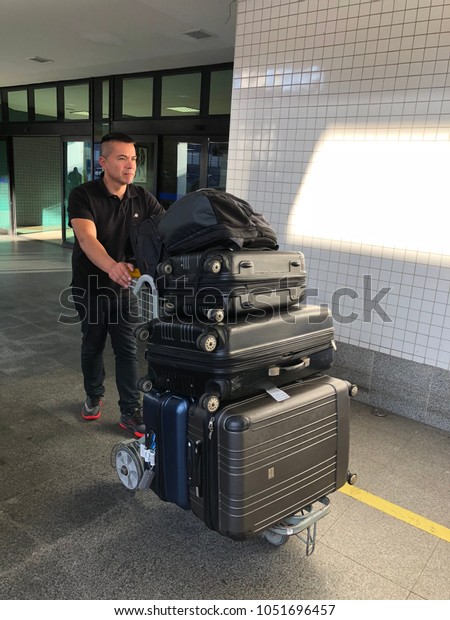SALVADOR, BAHIA, USA - MAR 10, 2018: Man\
carrying luggage at airport while\
traveling