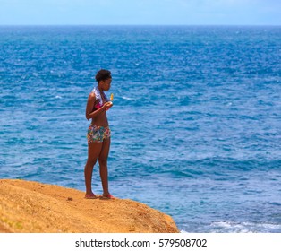 SALVADOR, BRAZIL, FEV 12, 2017: Black Woman Overlooking The Ocean, With A Popsicle In Her Hand