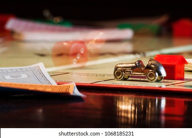 Salzburg, Austria - April 6 2010: Monopoly Boardgame With Rolling Dice Behind Golden Car And Paper Money