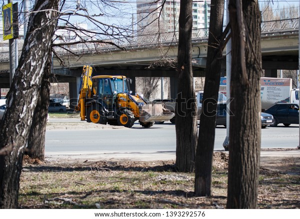 Samara. Rosiya.\
-April.18.2019: the tractor is moving along the factory highway in\
the stream of cars, on the ring with Kirov street in the direction\
of Aurora street