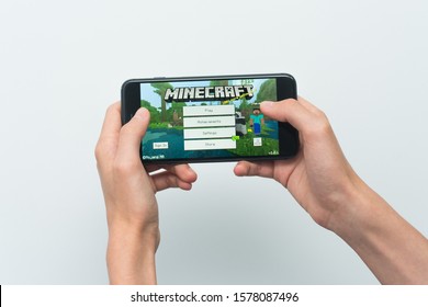 Samara, Russia -07, 29, 2019: Hands holding a smartphone Iphone 8 Plus with Minecraft game on display screen, Illustrative Editorial.