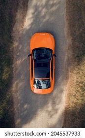 Samara, Russia - 09.05.2020: Aerial view of green forest and orange car AUDI A5 S line on the road. Forest road going through forest with car adventure view from above. Bird's eye. Travel concept