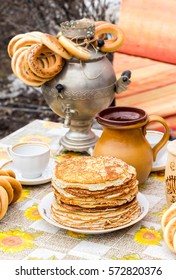 SAMARA, RUSSIA - MARCH 13, 2016: Appetizing Fried Pancakes And Samovar With Bagels During Russian Pancake Week