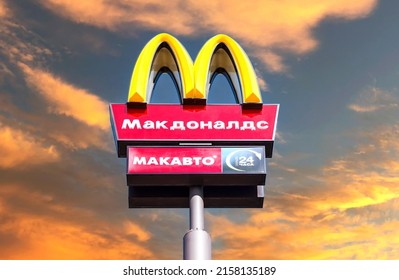 Samara, Russia - May 8, 2022: McDonald's logo on a pole against the sunset sky background. McDonald's is the world's largest chain of hamburger fast food restaurants