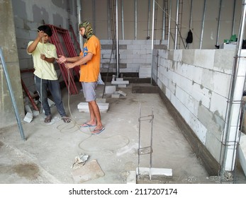 Samarinda, Indonesia - February 03, 2022 : Fitout progress of ramen restaurant, traditional spirit level used by workers for the initial work of laying light bricks