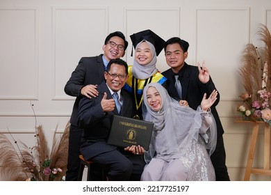 Samarinda, Jun 7, 22. A Muslim Student Celebrate Graduation With Family At Photo Studio. Asian Muslim Girl Hijab And Kebaya With Toga