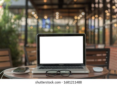 Samartphone And Laptop On Wooden Table With Flower And Notebook In The Garden