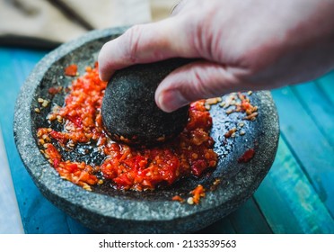 Sambal Ulek. A popular Indonesian condiment of fresh red chili peppers and tomato in traditional mortar and pestle