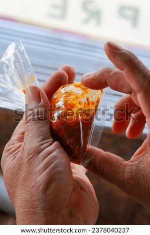 Sambal is wrapped in transparent plastic. Packed with two hands. Indonesian traditional sambal is made from red chili, green chili, garlic and other spices