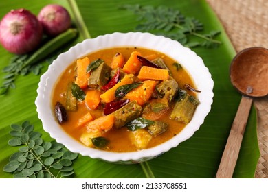 Sambar , Lentil sambar mixed vegetable curry soup for Onam sadhya vishu spicy hot isolated on green banana leaf. popular south Indian food in Kerala Tamil Nadu Sri lanka