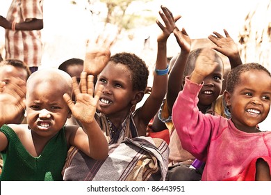 SAMBURU, KENYA - NOVEMBER 8: group of African unidentified kids, 3 to 6 years old, with hands up at outdoor school on November 8, 2008 in tribal village near Samburu National Park Reserve, Kenya.