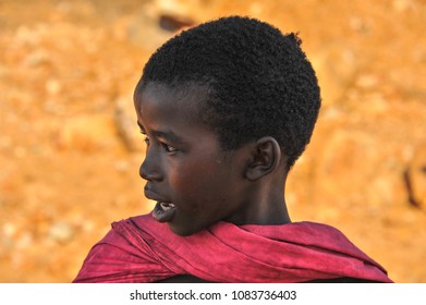 Samburu, Rift Valley, Kenya - August 2014: Portrait Of A Beautiful Young Boy, Goat Herder At Sunset. Head And Shoulders, Profile Image Wearing Red Traditional Dress 