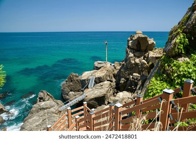 Samcheok City, South Korea - May 18, 2024: The rugged rocky cliffs and vibrant turquoise waters of the East Sea, as seen from a viewpoint along Isabu Road, offer a breathtaking coastal landscape. - Powered by Shutterstock