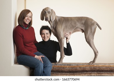 A Same Sex Couple, Two Women Posing With Their Weimaraner Pedigree Dog.