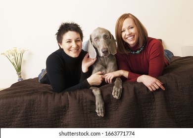 A Same Sex Couple, Two Women With Their Weimaranar Pedigree Dog Between Them.