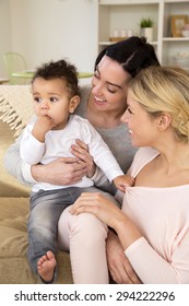 Same Sex Femal Couple Sitting With Their Son At Home