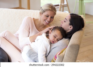 Same Sex Female Couple Lying Down With Their Baby Son