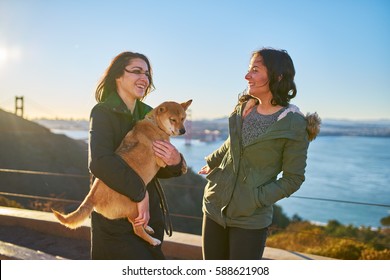 Same Sex Lesbian Couple With Pet Dog Shiba Inu On Hills In Front Of Golden Gate Bridge