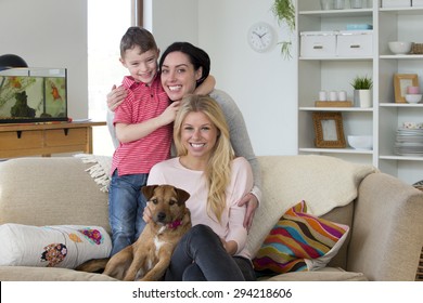 Same Sex Male Couple Smiling For The Camera With Their Daughters At Home. 