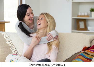 Same Sex Male Couple Smiling For The Camera With Their Daughters At Home. 