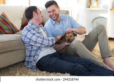 Same Sex Male Couple Smiling For The Camera With Their Daughters At Home. 