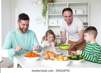 Same Sex Male Couple Smiling For The Camera With Their Daughters At Home. 