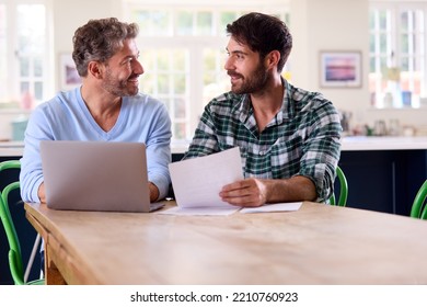 Same Sex Male Couple Using Laptop At Home To Check Domestic Finances