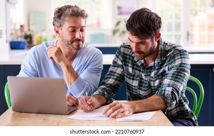 Same Sex Male Couple Using Laptop At Home To Check Domestic Finances