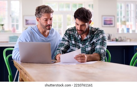 Same Sex Male Couple Using Laptop At Home To Check Domestic Finances