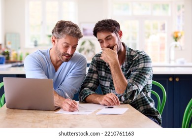 Same Sex Male Couple Using Laptop At Home To Check Domestic Finances