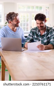 Same Sex Male Couple Using Laptop At Home To Check Domestic Finances