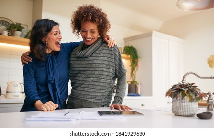 Same Sex Mature Female Couple Reviewing Domestic Finances And Investments In Kitchen At Home