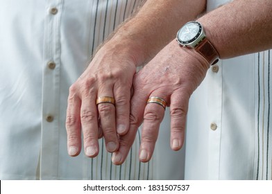 Same Sex Older Caucasian Male Couple Show Off Their Wedding Rings.