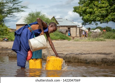 Same, Tanzania, 8th June, 2019:  Maasai woman  at a muddy stream to  collect drinking water