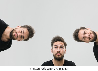 Same Young Man Captured With Different Facial Expressions, Against Grey Background. Copy Space Available