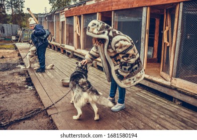 Sami Village, Sam-Syyt / Russia - August 6 2019: A Girl In Sami Clothes Strokes A Husky Dog