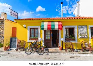 SAMOS ISLAND, GREECE - SEP 24, 2015: Bicycle Parked In Front Of Italian Restaurant On Street Of Kokkari Town, Samos Island, Greece