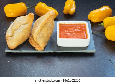 Samosas with yellow hot chilli peppers and red sauce