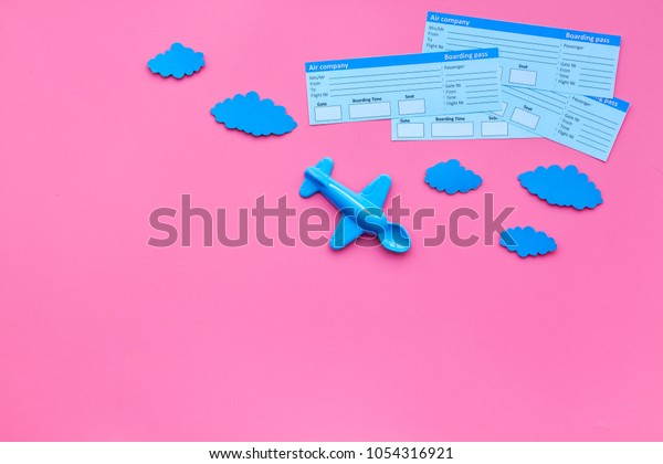Sample of
airplane ticket. Family trip with kid. Airplan toy and paper
clouds. Pink background flat lay space for
text