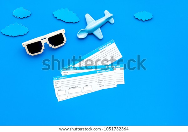 Sample of\
airplane ticket. Traveling with family and child. Glasses and plane\
model on blue background top view mock\
up