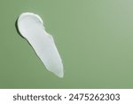 Sample of face cream on green background, top view. Space for text